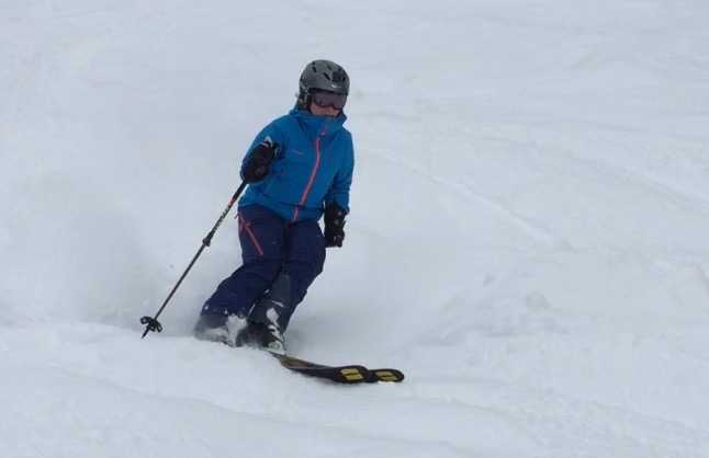 Young Anna making easy turns in light powder.